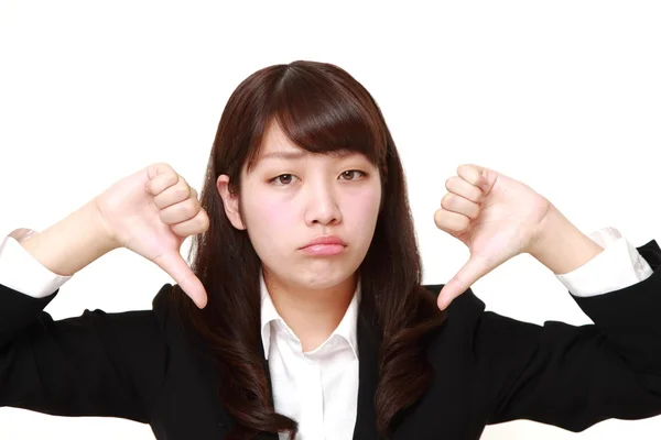 Jovem empresária japonesa com polegares para baixo gesto — Fotografia de Stock