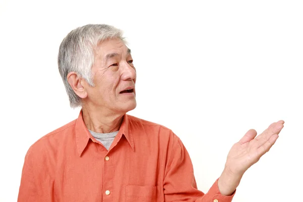 Sênior japonês homem apresentando e mostrando algo — Fotografia de Stock