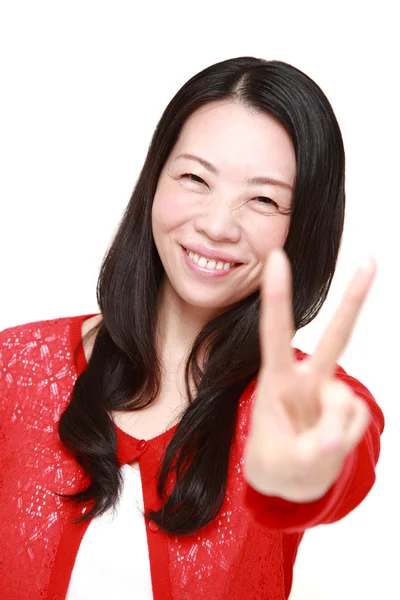 Unga japanska kvinnan visar ett tecken på seger — Stockfoto