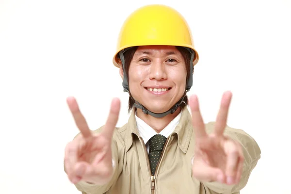 Mladá japonská stavební dělník ukazuje znak vítězství — Stock fotografie