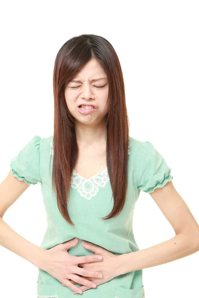 Jovem mulher japonesa sofre de dor de estômago — Fotografia de Stock