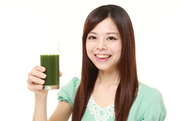 Junge Japanerin mit grünem Gemüsesaft — Stockfoto