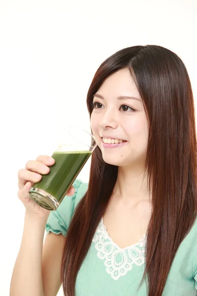 Young Japanese woman with green vegetable juice — Stock Photo, Image