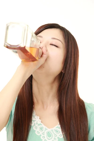 Young Japanese woman drinking straight from a bottle — Stock Photo, Image