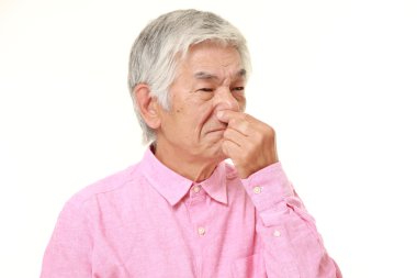 kötü bir koku yüzünden burnunu tutarak üst düzey Japon adam