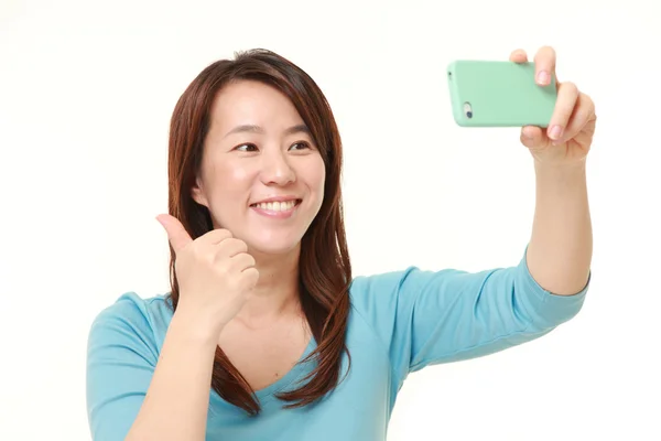Japoński kobieta w średnim wieku trwa selfie — Zdjęcie stockowe