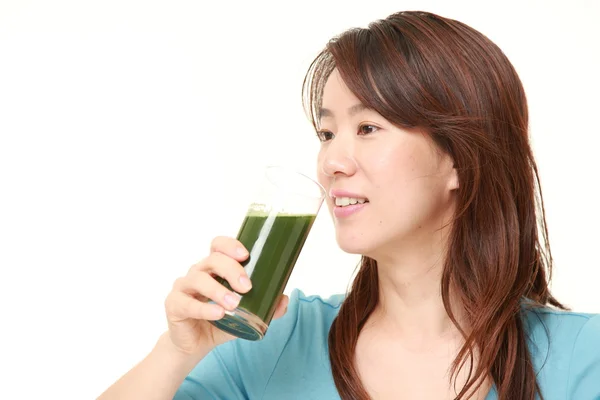 Mellersta åldern japansk kvinna med gröna grönsaksjuice — Stockfoto