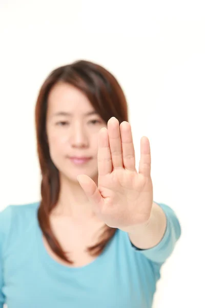 Японская женщина средних лет делает остановку жеста — стоковое фото