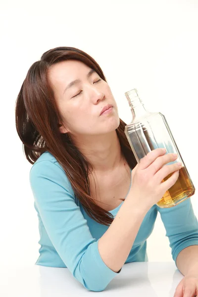 Middle aged Japanese Woman drinking straight from a bottle — Stock Photo, Image