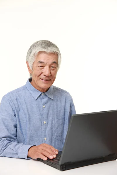 Старший японский человек с помощью ноутбука — стоковое фото