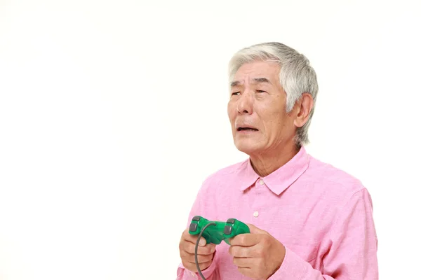 Senior japansk man förlorar spela video spel — Stockfoto