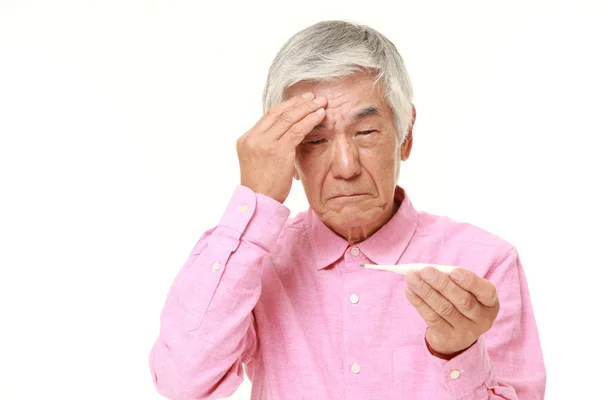 Старший японский мужчина с температурой — стоковое фото