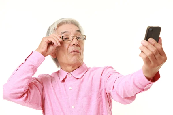 Starší japonský muž s presbyopie — Stock fotografie