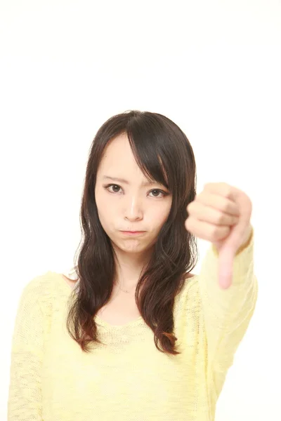 Jeune femme japonaise avec les pouces vers le bas geste — Photo