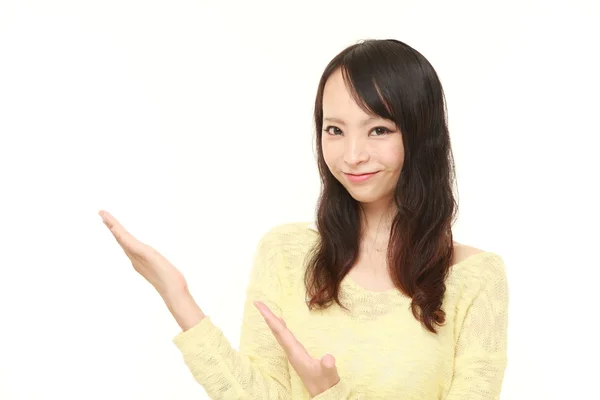 Junge Japanerin präsentiert und zeigt etwas — Stockfoto