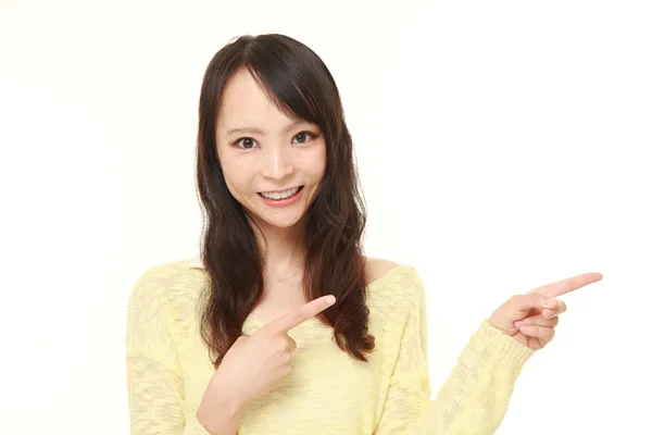 Joven japonesa mujer presentando y mostrando algo — Foto de Stock