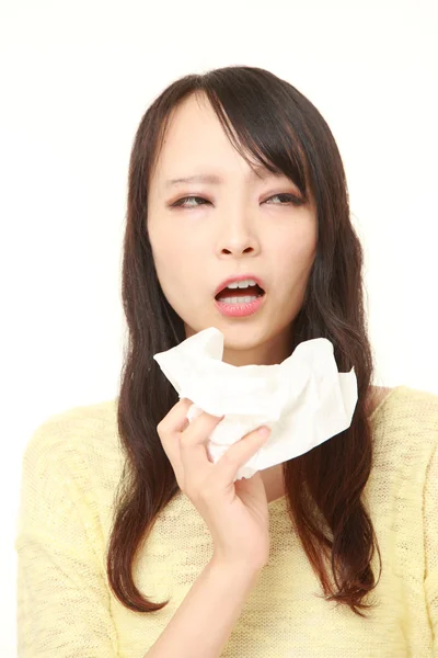 Young woman with an allergy sneezing into tissue — Stock Photo, Image