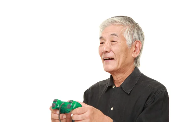 Sênior japonês homem desfrutando de um vídeo game — Fotografia de Stock