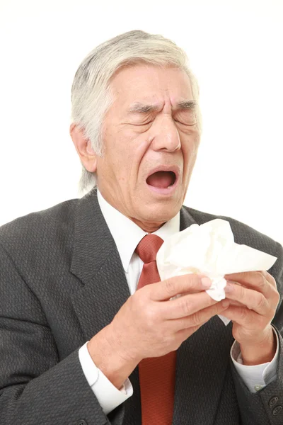 Japanischer Geschäftsmann mit einer Allergie, die ins Gewebe niest — Stockfoto