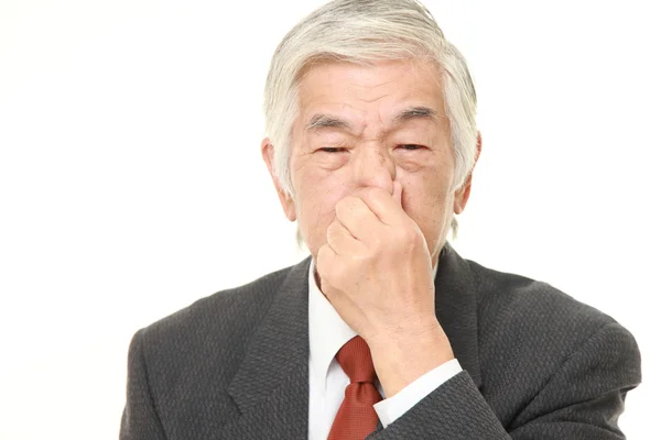 Magas rangú japán üzletember gazdaság az orrát, mert rossz a szaga — Stock Fotó