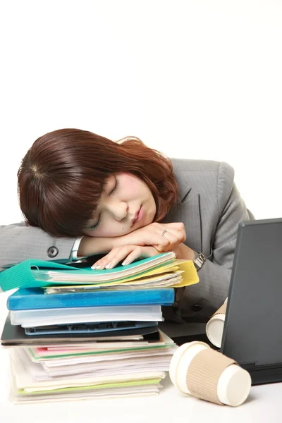 Jovem empresária japonesa dormindo na mesa — Fotografia de Stock