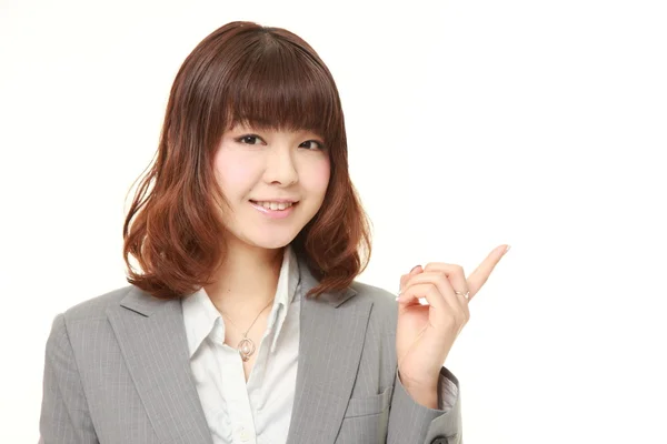 Joven mujer de negocios japonesa presentando y mostrando algo —  Fotos de Stock