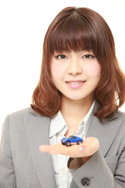Empresária japonesa com um carro em miniatura — Fotografia de Stock