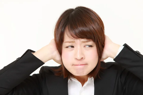 Young Japanese businesswoman suffers from noise — Stock Photo, Image