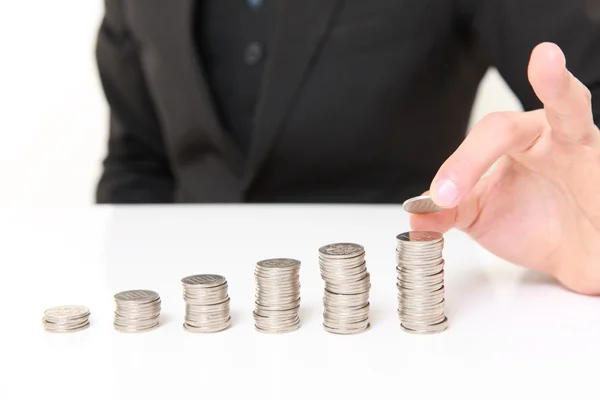 Empresario poner monedas a pila de monedas — Foto de Stock