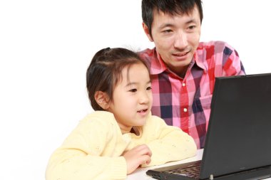 Japon baba ve kızı dizüstü bilgisayar üzerinde
