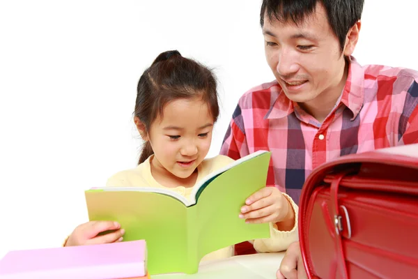 Отец помогает своей дочери делать домашнее задание — стоковое фото