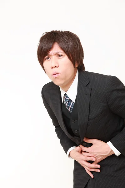 Young Japanese businessman suffers from stomachache — Stock Photo, Image