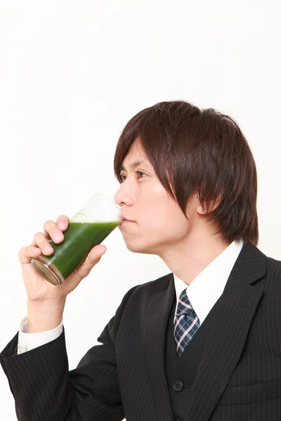 Japanese businessman with green vegetable juice — Stock Photo, Image
