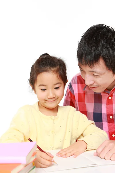 Отец помогает своей дочери делать домашнее задание — стоковое фото