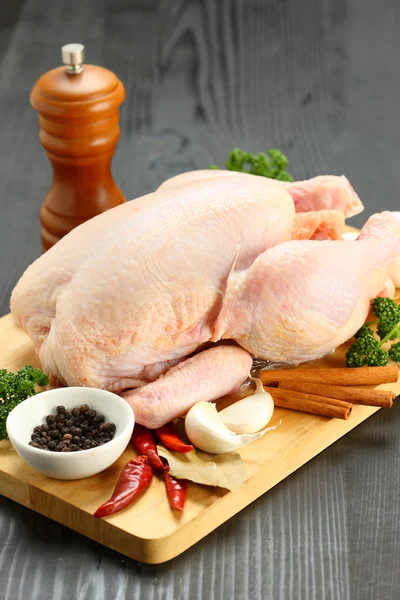 Bir kesme tahtası üzerinde bütün tavuk