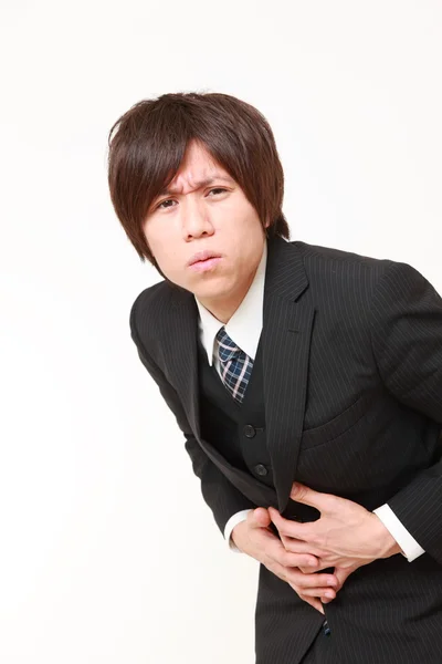 Jonge Japanse zakenman lijdt aan buikpijn — Stockfoto
