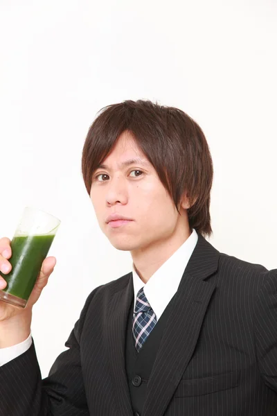 Japanese businessman with green vegetable juice — Stock Photo, Image