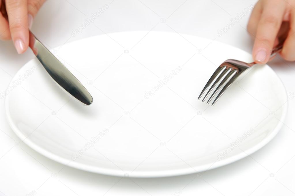 Fork and a knife with empty dish