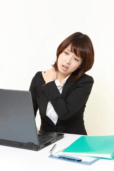 Japanese businesswoman suffers from neck ache — Stock Photo, Image