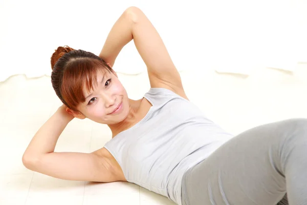 Jovem mulher japonesa fazendo exercício físico — Fotografia de Stock