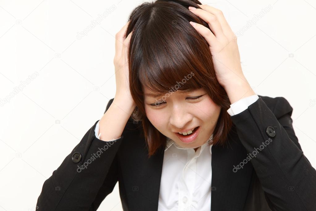 Frustrated young businesswoman pulling her hair