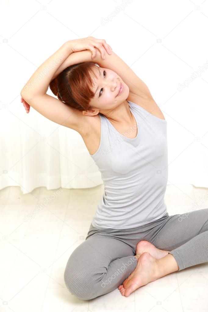 Young woman doing shoulder stretch