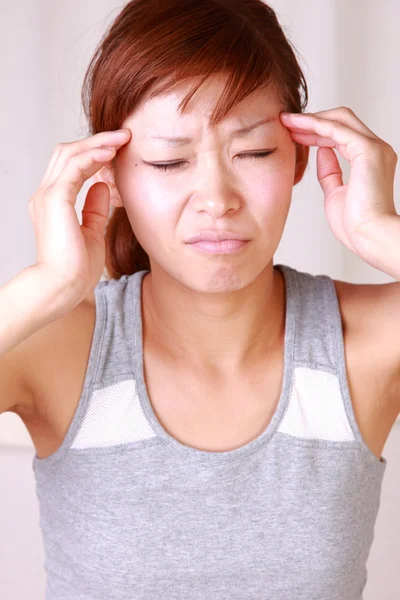 Jonge Japanse vrouw lijdt aan hoofdpijn — Stockfoto