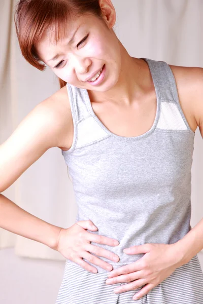 Young Japanese woman suffers from stomachache — Stock Photo, Image