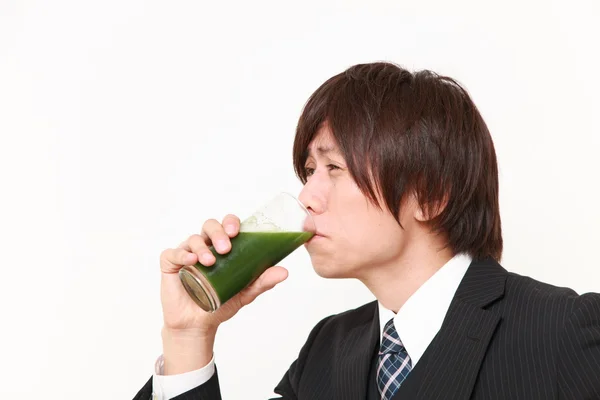 Japanese businessman with green vegetable juice — Stock Photo, Image