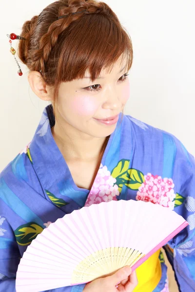 Junge Frau trägt japanischen Kimono mit Papierfächer — Stockfoto