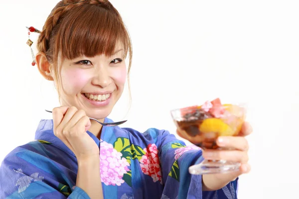 Νεαρή γυναίκα που φοράει τα κιμονό έχοντας ιαπωνική παραδοσιακή φασολάδα μαρμελάδα επιδόρπιο — Φωτογραφία Αρχείου
