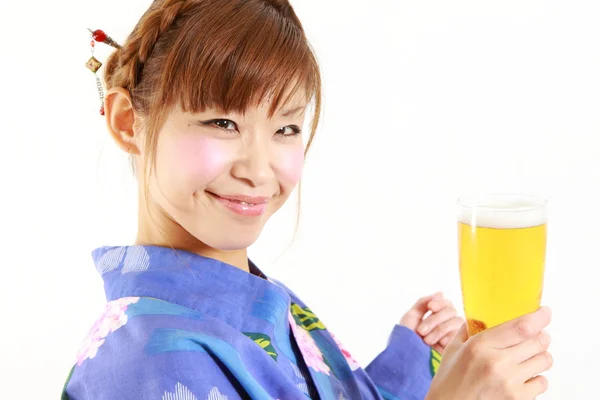 Bir bardak bira ile Japon kimono giyen genç kadın — Stok fotoğraf