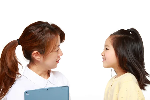 Verpleegkundige gesprekken aan een kind patiënt — Stockfoto