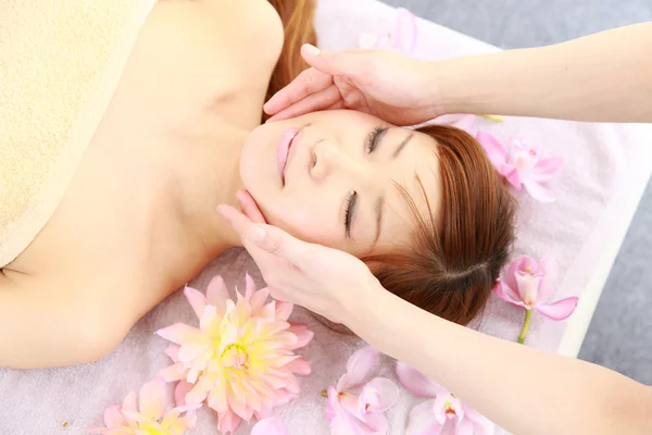 Jovem mulher japonesa recebendo uma massagem facial — Fotografia de Stock